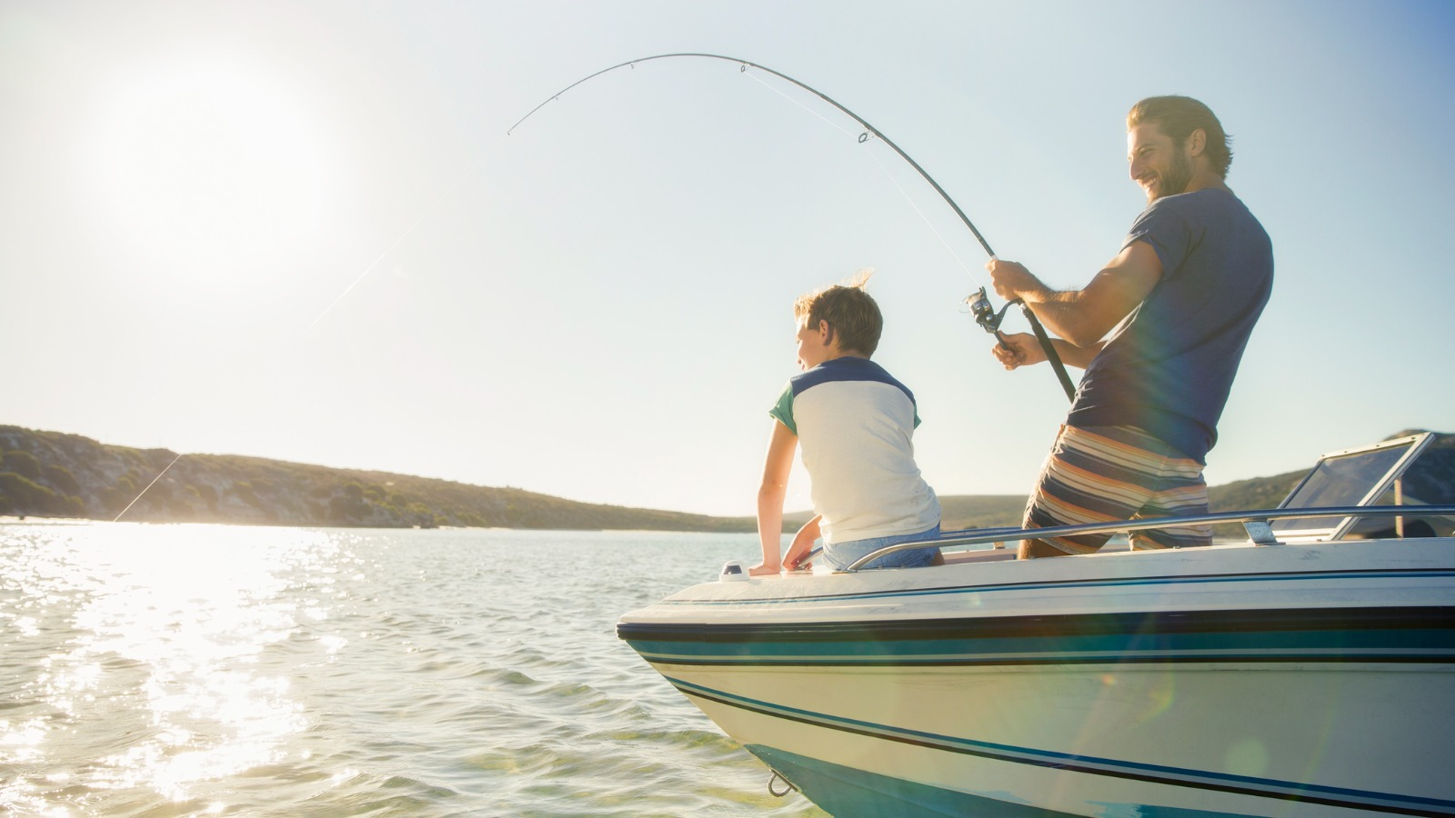 Father and son on a boat father and son fishing on a lake